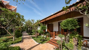 Un sendero conduce a un edificio con tejado de baldosas y fachada de madera.