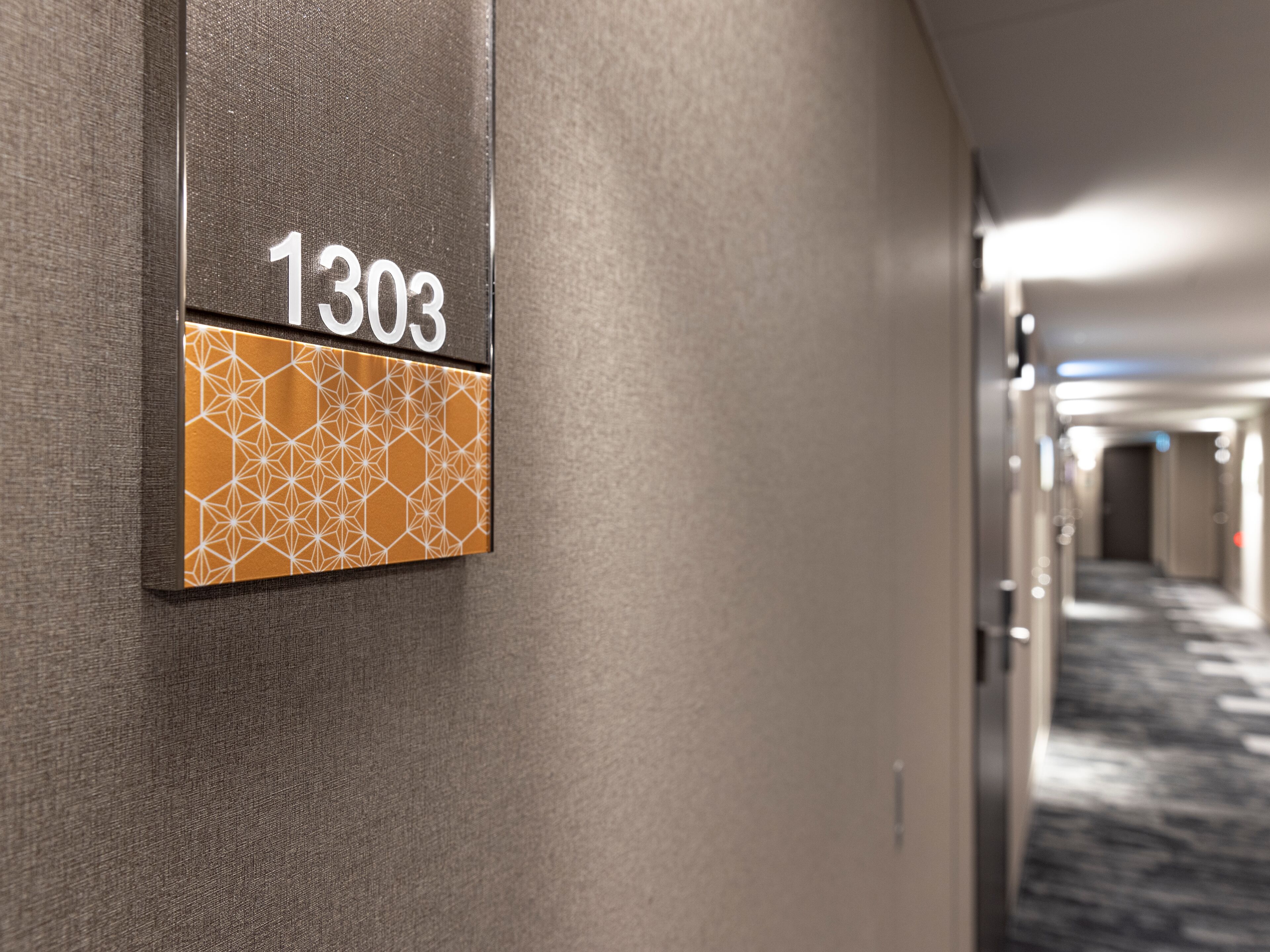 Corredor com uma placa indicando o quarto 1303.