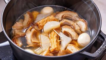 Una olla con diversos ingredientes hirviendo en agua, entre ellos carne y verduras.