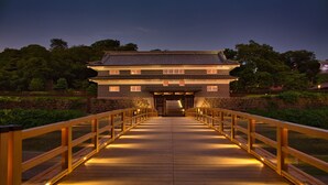 Edifici japonès tradicional amb un camí de fusta que condueix a l'entrada.