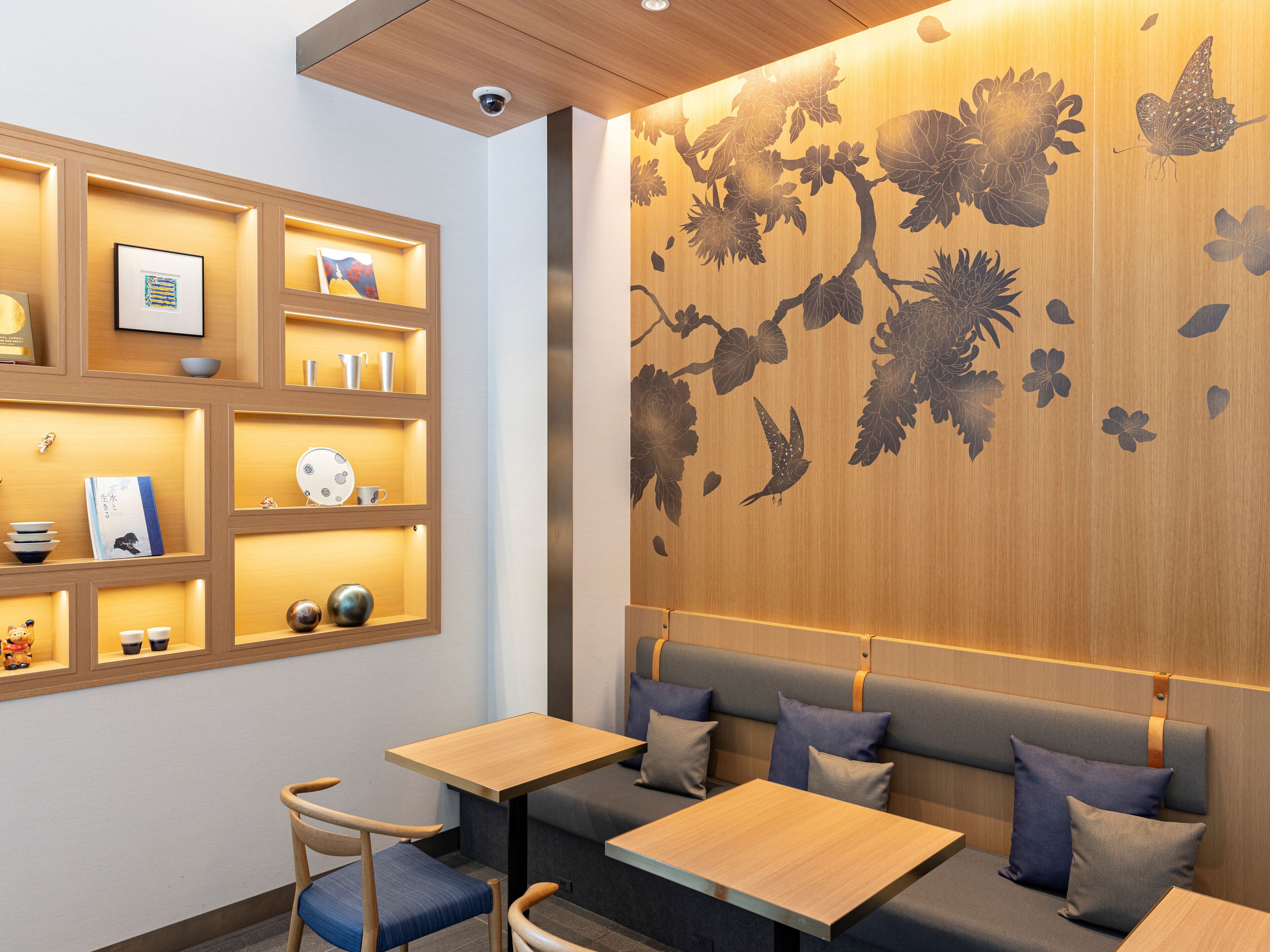 A modern interior with wooden paneling, a wall mural, and seating areas.