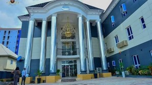 A building with a grand entrance, large columns, and a chandelier. - JJ Mas Hotel (Owerri)