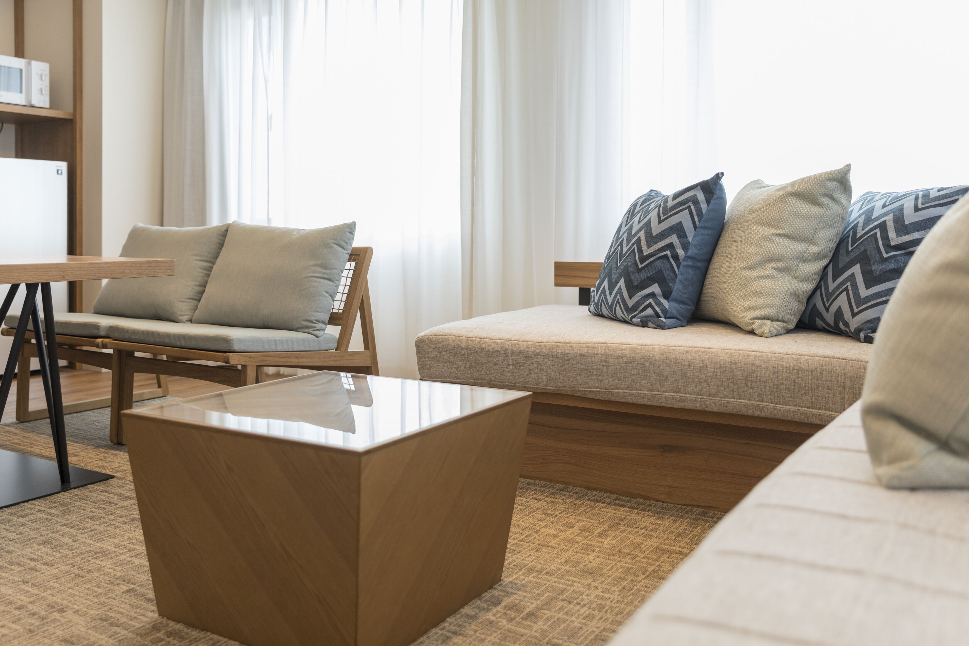 Una sala moderna con un sofá, una mesa de centro de madera y una silla.