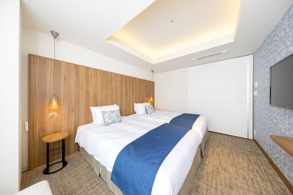 Una habitación de hotel moderna con una cama grande, un panel de pared de madera y un televisor de pantalla plana.
