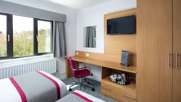 A hotel room with two beds, a desk, a chair, a TV, and a wardrobe.