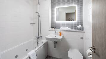 A modern bathroom with a bathtub, shower, sink, and toilet.