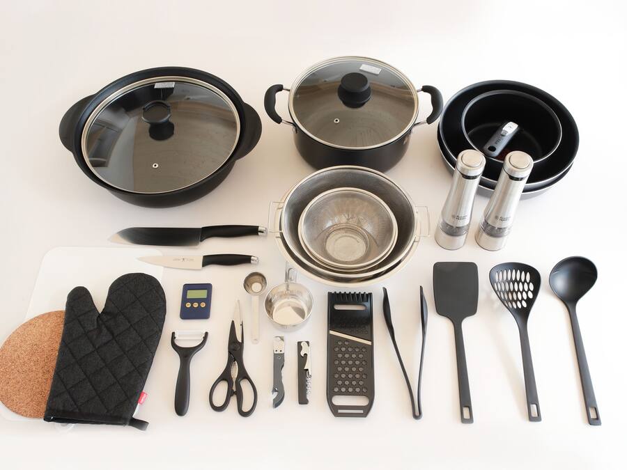 A kitchen setup with cookware, utensils, and a cutting board.