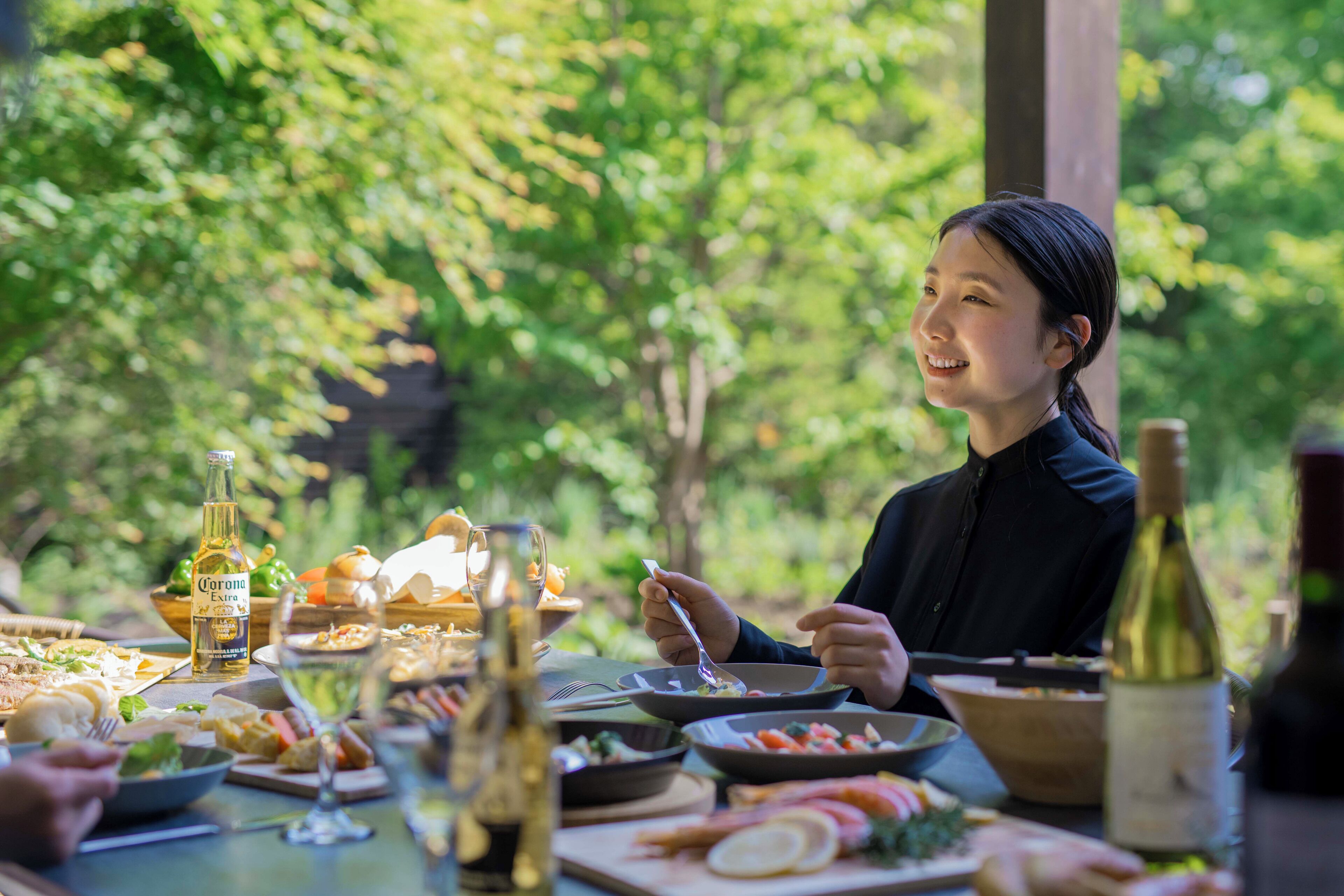 A dining table set with various dishes, a bottle of wine, and a glass of water.