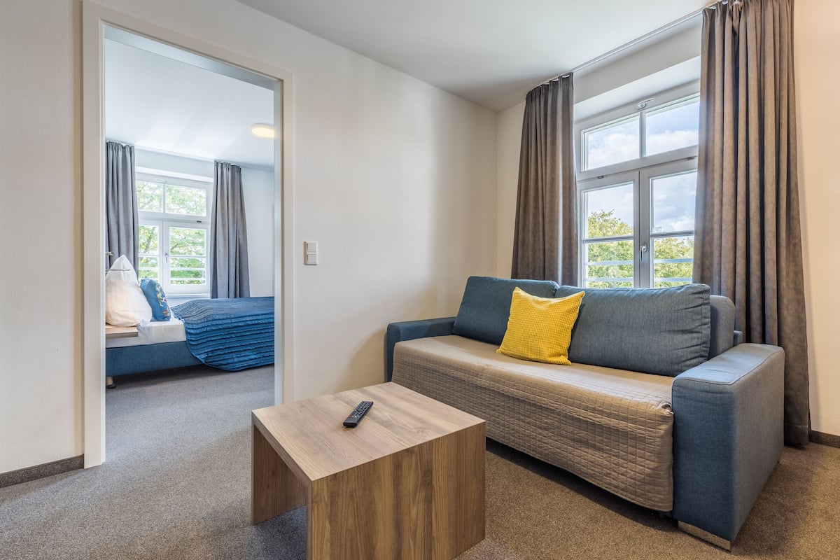 Junior suite | Woonkamer | Een 102-cm flatscreentelevisie met digitale zenders en een televisie