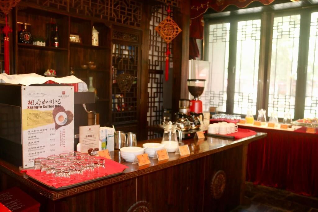 A traditional Chinese tea house with a wooden counter displaying various tea sets and teapots.