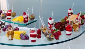 Variedad de bebidas y postres a base de fruta en una vitrina de vidrio.