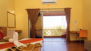 Une chambre d’hôtel avec un lit, un bureau, la climatisation et un balcon avec vue.