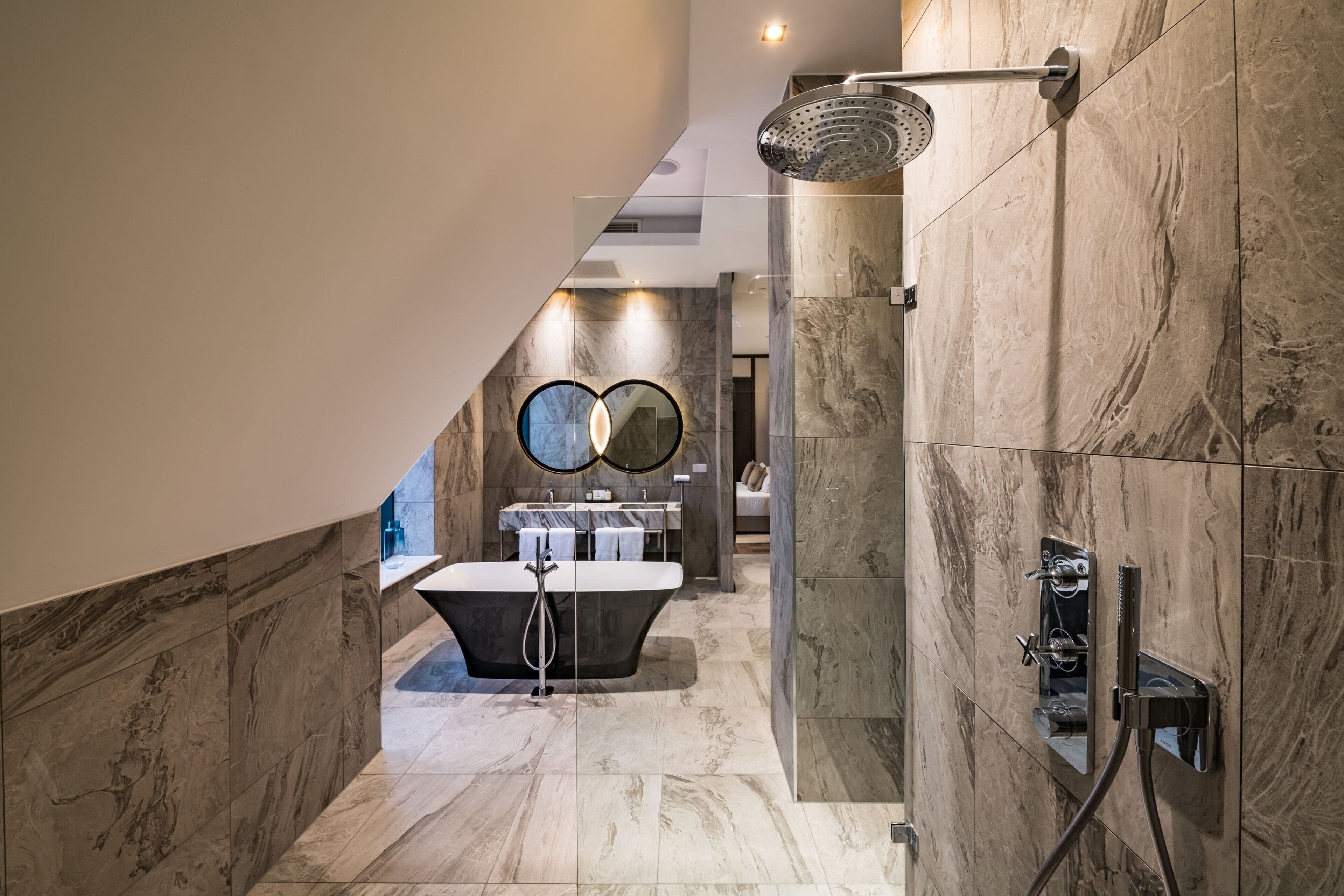 Un baño moderno con una bañera independiente, ducha y tocador con espejo.