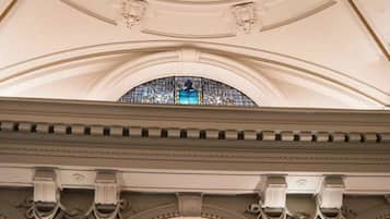 Um interior arquitetônico imponente com teto alto abobadado e janelas em arco.