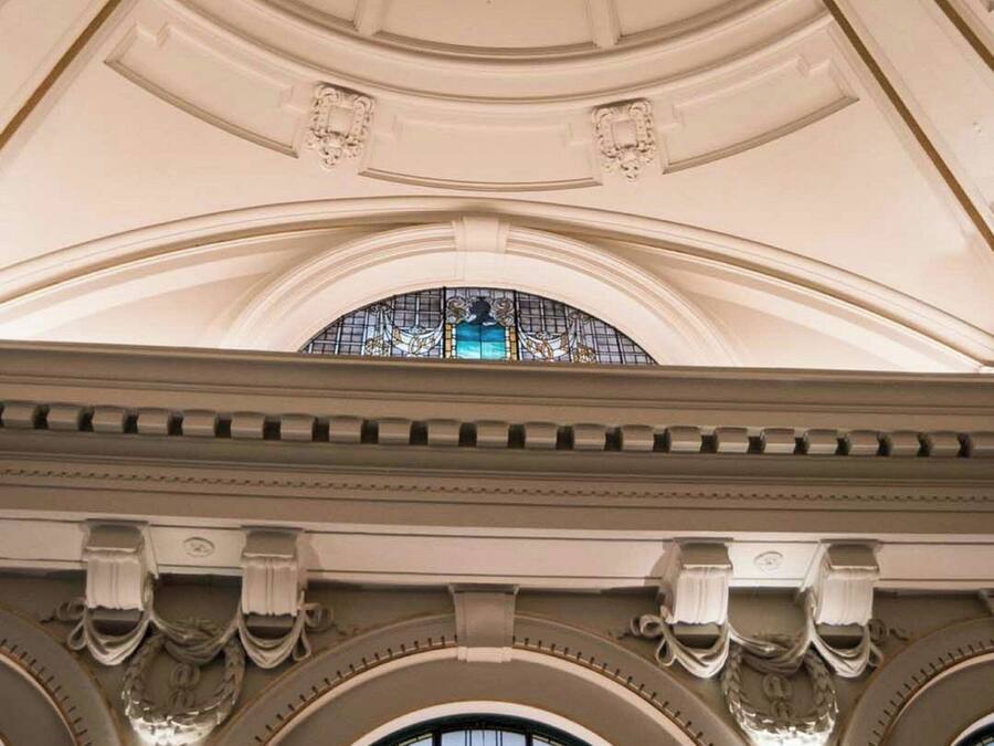 Um interior arquitetônico imponente com teto alto abobadado e janelas em arco.