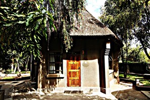 A small building with a thatched roof, a wooden door, and a number '3' above the door.