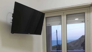 Habitación con puerta de cristal corredera que da a un espacio exterior con vistas al mar.