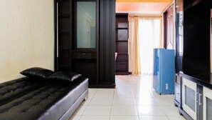 A compact room with a bed, a TV, a blue refrigerator, and a wardrobe. - 2BR Apartment at Great Western Serpong (Tangerang)