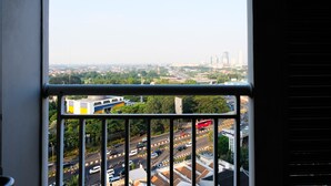 A cityscape through a window with a balcony railing. - 2BR Apartment at Great Western Serpong (Tangerang)