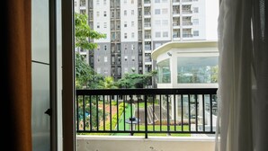 A balcony with a view of a residential building and a well-maintained garden.