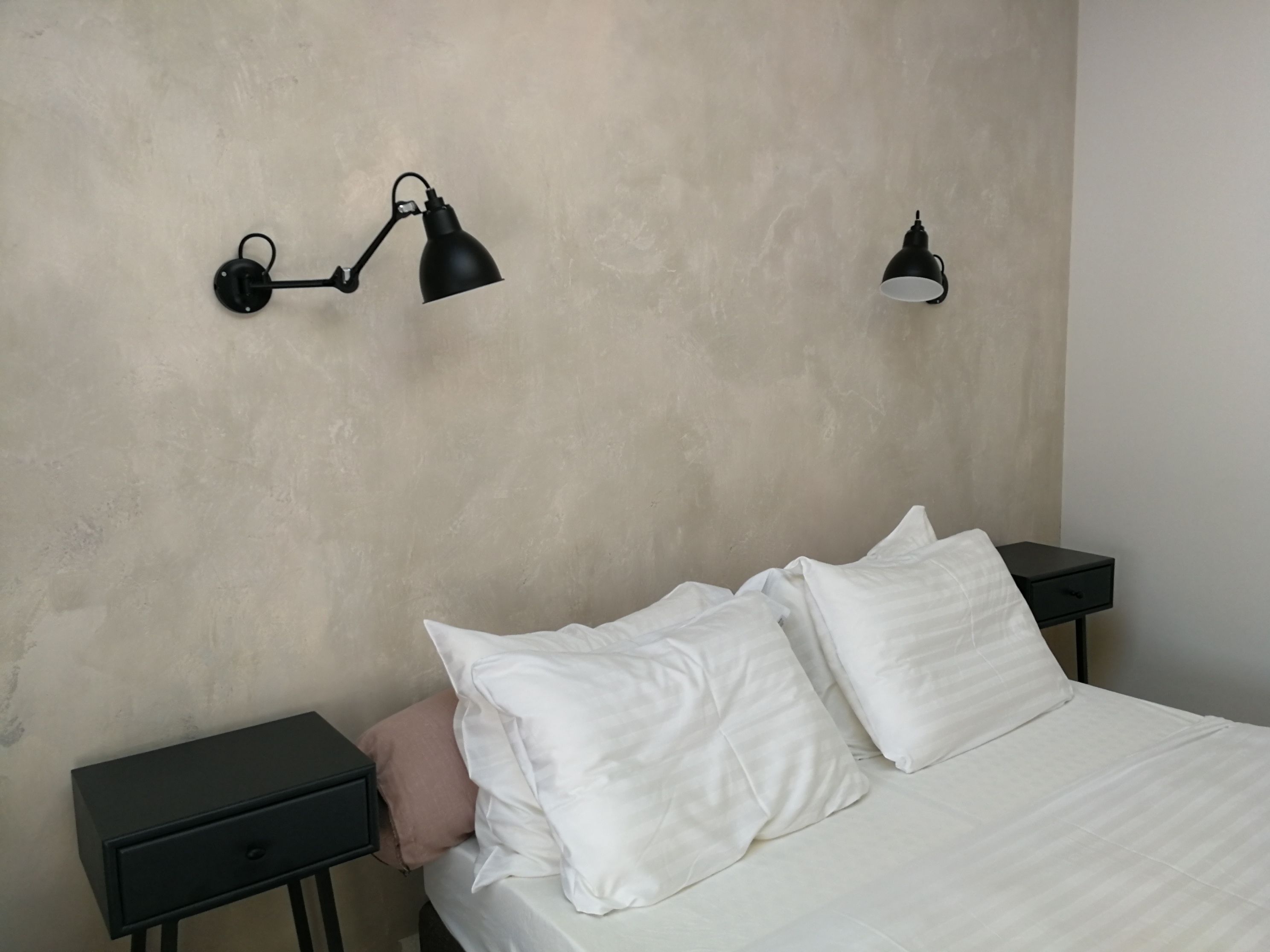 Ein Schlafzimmer mit einem Bett, zwei Nachttischen und zwei Wandlampen.