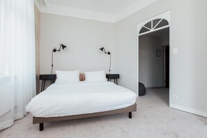 A bedroom with a large bed, two bedside tables, and two wall-mounted lamps. - Hotel Babula am Augarten (Vienna)