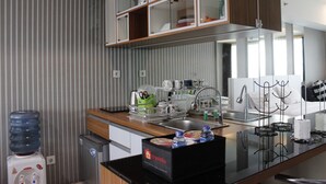 Une cuisine moderne équipée d’un distributeur d’eau, d’une machine à café et d’une boîte décorative sur le plan de travail, le tout sur le thème du voyage.
