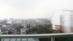 Un paysage urbain mêlant des immeubles résidentiels et commerciaux, dont un bâtiment blanc imposant dont la façade est ornée de lignes verticales.