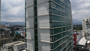 A high-rise building with multiple floors, large windows, and a modern architectural design. - City View Studio Apartment at Tamansari La Grande (Bandung)