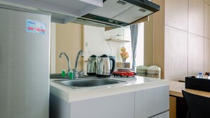 A modern kitchen with a stainless steel refrigerator, a sink, and a kettle. - Comfortable 1BR Tree Park Apartment (South Tangerang)