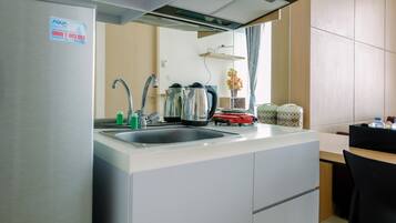 Kamer | Privékeuken | Een koelkast, een kookplaat, een waterkoker, kookgerei, borden en bestek