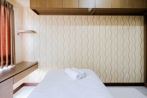 Relax in a stylishly designed room with a comfortable bed, a wooden headboard, and a wavy wall pattern.