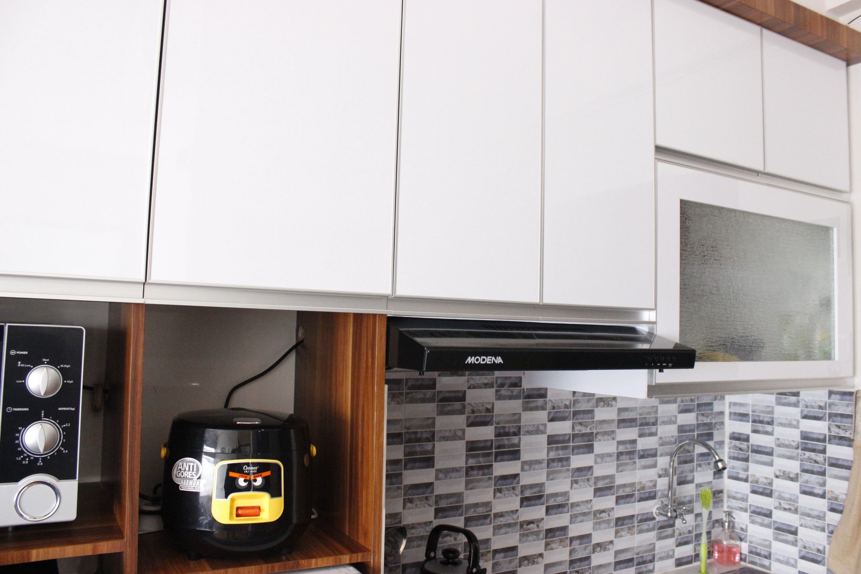 A kitchen with white cabinets, a microwave, a coffee maker, and a kettle.
