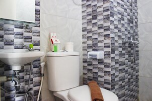 Une salle de bain avec des toilettes, un lavabo et une douche.