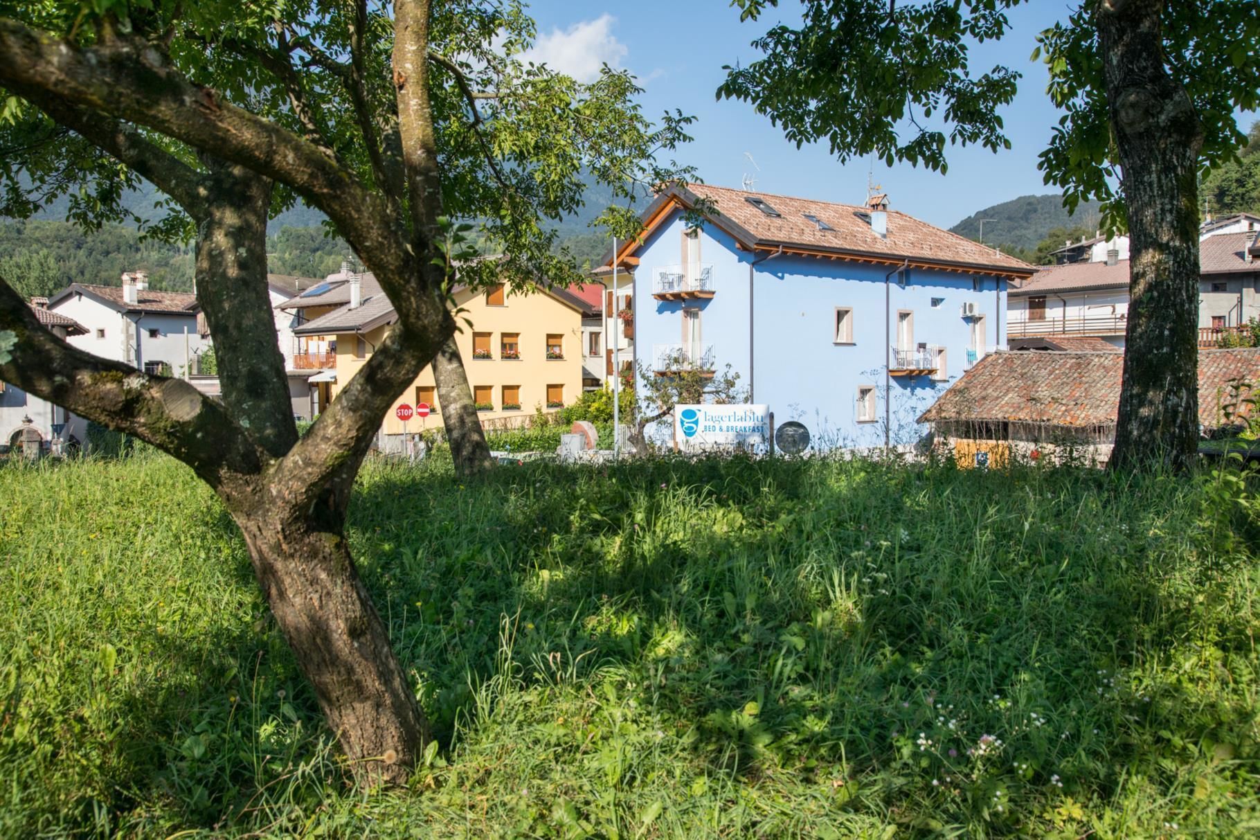 Un edificio tradizionale con facciata blu, tetto rosso e una insegna che indica che si tratta di un bed and breakfast.