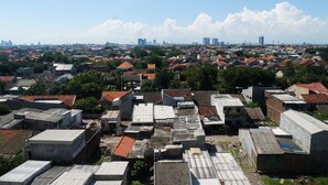 An aerial view of a densely packed urban area with various buildings, including residential and commercial structures. - Comfy Studio Apartment at Menara Rungkut (Surabaya)
