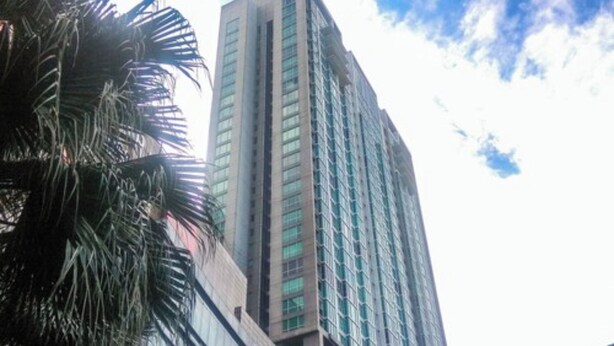 A tall, modern building with a glass facade and a prominent entrance. - Cozy and Elegant 2BR Kemang Village Apartment (Jakarta)