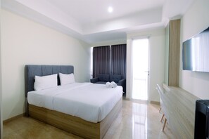 Relax in comfort with a large bed, sofa, and flat-screen TV in this inviting space.