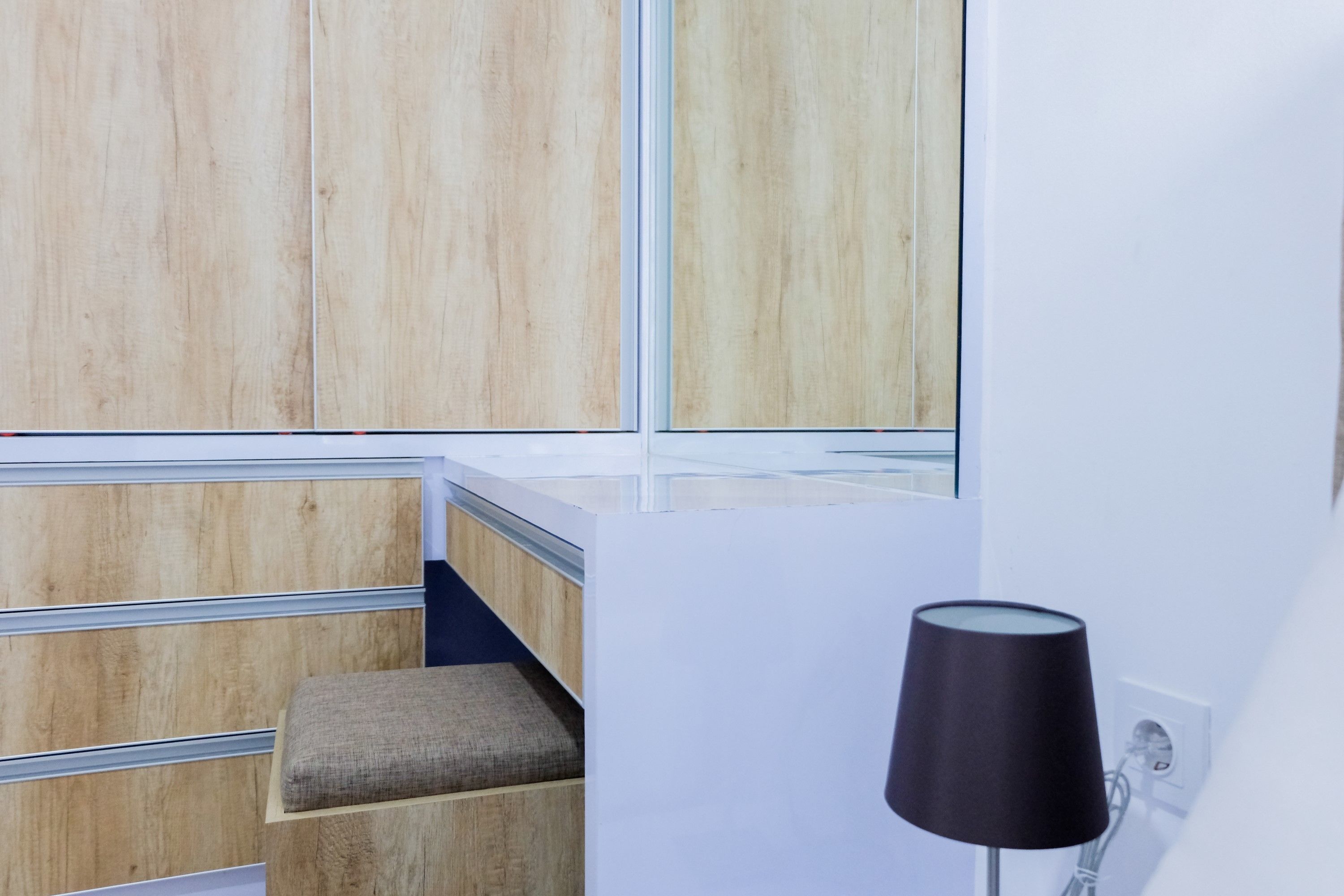 Une chambre moderne avec un banc en bois, une lampe noire et une fenêtre donnant sur un beau paysage.