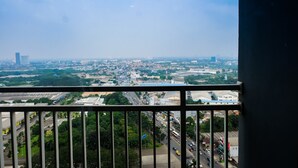 Stadsgezicht vanuit een balkon met een metalen hekwerk.