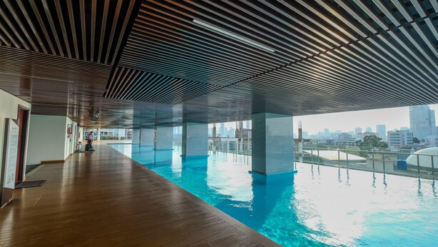 An indoor swimming pool with a wooden floor and a city view.