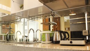 Une cuisine moderne dotée d’appareils électroménagers en acier inoxydable, d’un plan de travail en granit et d’un évier apparent.