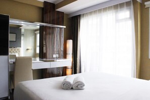 Relax in a stylish room with a comfortable bed, a large mirror, and a convenient desk area.