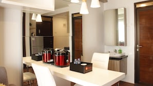 A hotel room with a dining area, a kitchen, and a bathroom. - Gorgeous 2BR Apartment at Gateway Pasteur near Exit Toll (Cimahi)