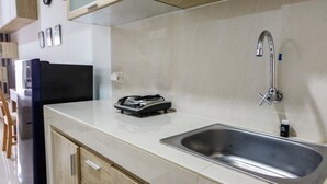 A modern kitchen with a stainless steel sink, a built-in stove, and wooden cabinetry.