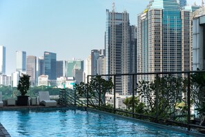 Una piscina en la azotea con un horizonte urbano de fondo.