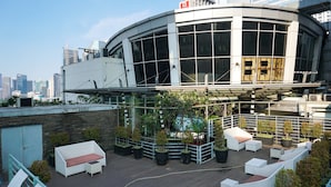 Eine Dachterrasse mit Sitzgelegenheiten im Freien und Topfpflanzen.