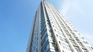 Ein hohes, modernes Hochhaus vor blauem Himmel.