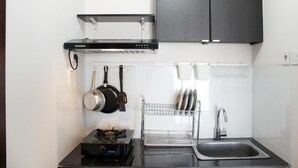 Una cucina moderna con piano cottura nero, lavello in acciaio inossidabile e cappa aspirante nera.
