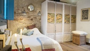 Un dormitorio con cama, armario, mesita de noche y lámpara.